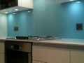 Blue back painted toughen splashback in northern ireland with glass cut outs for plugs.png